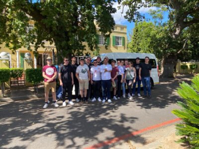 a group of people in front of a car